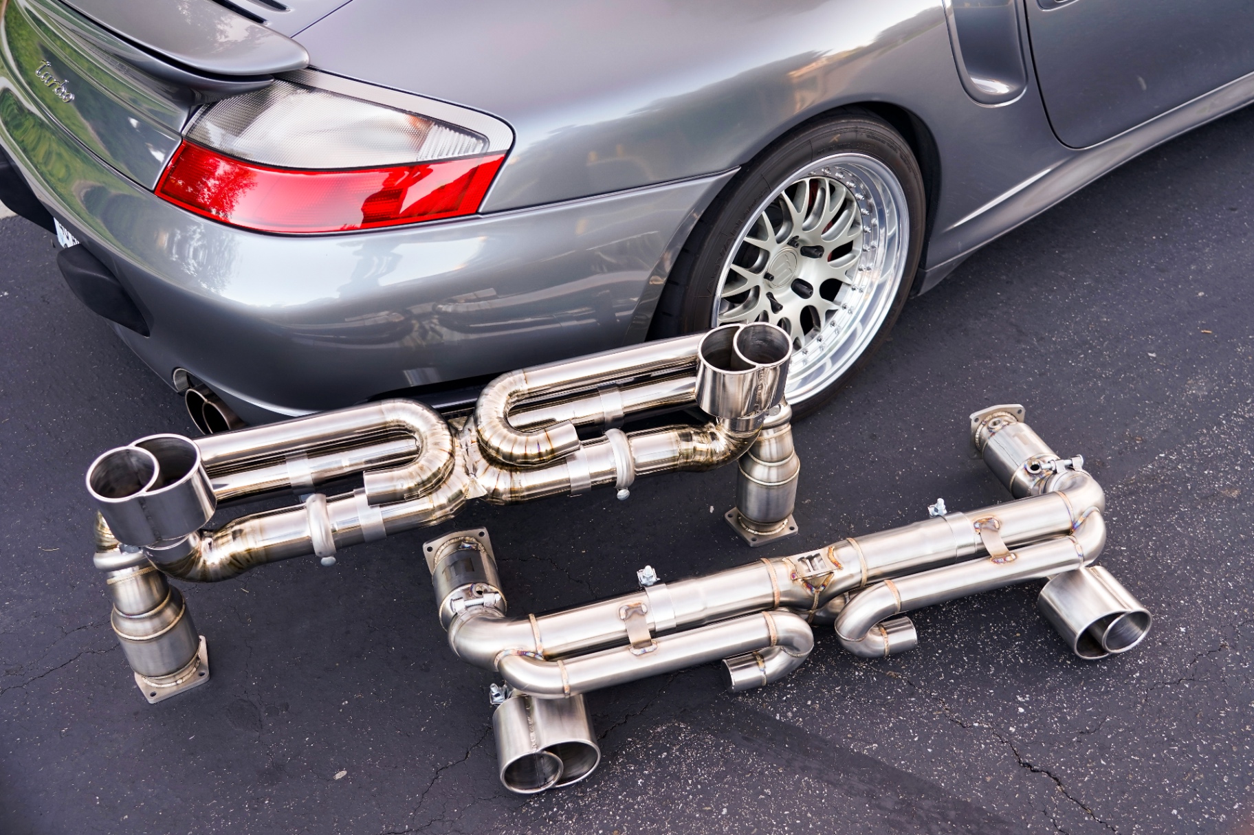 Titanium and stainless steel exhaust systems side by side next to 996 Turbo